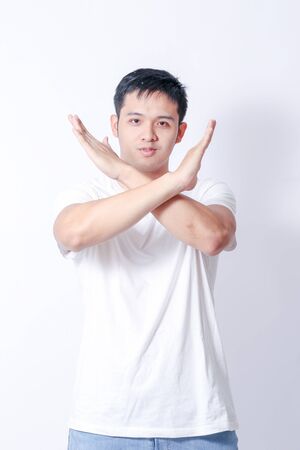 A Portrait of young asian man in white shirt and blue jeans  showing gesture sign or devicesの写真素材