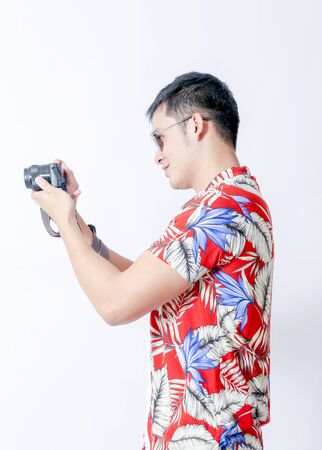 A Portrait of young tourist asian man wearing floral shirt and showing gesture sign
 or laptop, Smartphone, camera  and wallet stand in isolated backgroundの写真素材