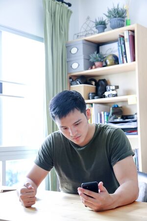 young asian wearing a green shirt working with laptop in home officeの写真素材