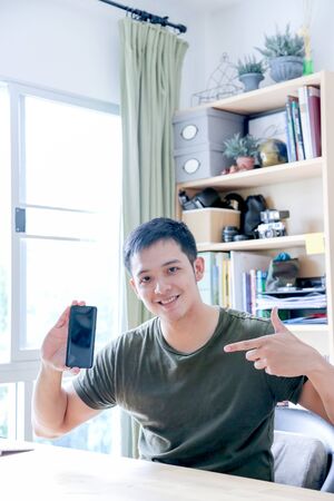 young asian wearing a green shirt working with laptop in home officeの写真素材