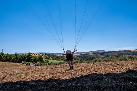 Black haired latino man trying to take off with his paragliderの写真素材