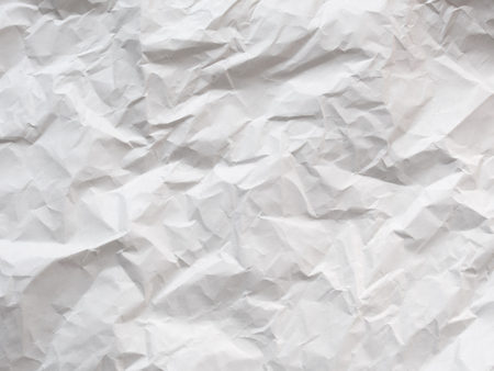crumpled blank sheet of paper, light gray textured backgroundの写真素材
