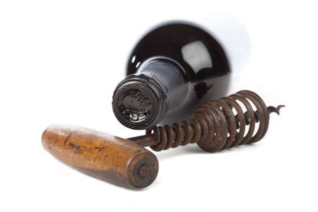 Old corkscrew with wood grip and wine bottleの写真素材