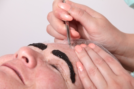 Beautician removed at a customer in a beauty salon skin blemishesの写真素材