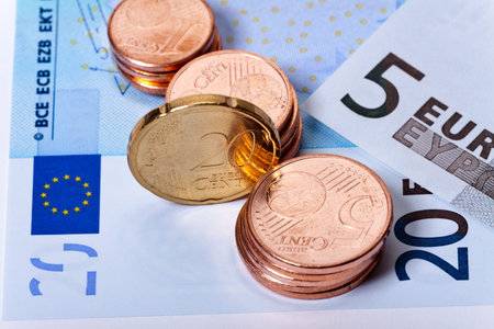 Shiny euro coins stacks and banknotes as close up view