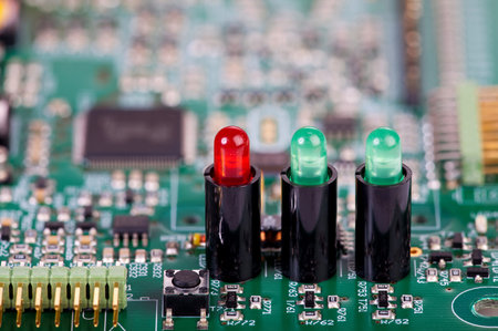 Two green and one red LED in sockets on a circuit board