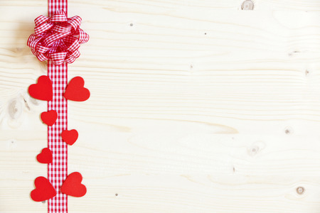 Large advertising space on wood with red hearts and a ribbon with a bowの写真素材