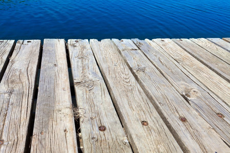 Old bathing jetty from old gray hardwood at the lakeの写真素材