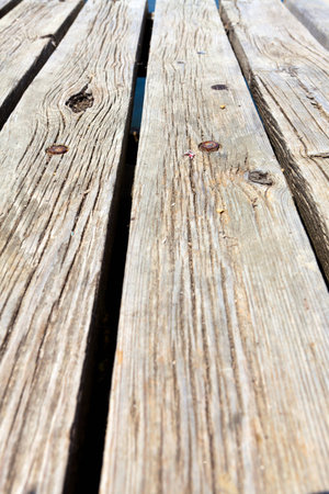 Diagonal view across old gray hard planks of a bathing jetty