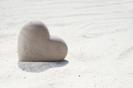 Large stone heart on the sandy beachの写真素材