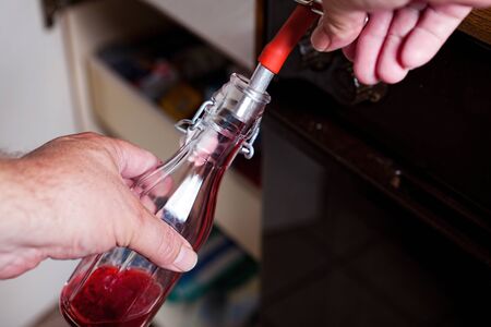 Bottled currant syrup from the steam juicer into swing top bottlesの写真素材