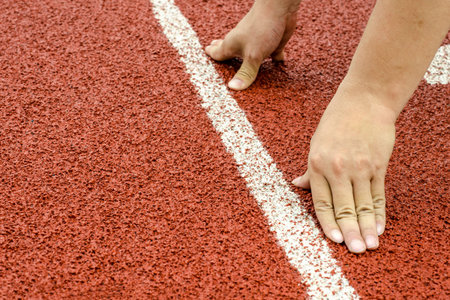 The hands on starting line in race track, ready for runningの写真素材