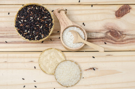 Top view of the black and white rice in the bowl on the wooden tableの写真素材