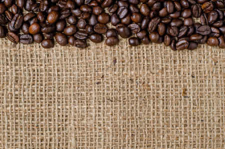 The coffee beans in the bowl on the hessian sack  for background , texture , copy textの写真素材