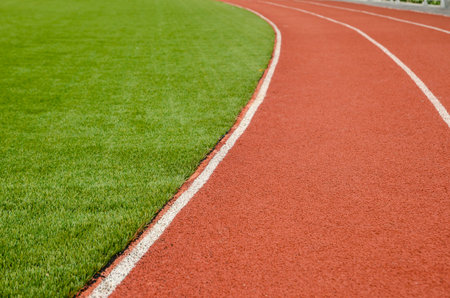 The running track rubber lanes in the artificial grass stadium.の写真素材