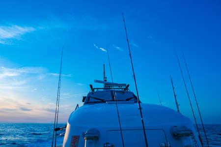 Fishing boat running in the sea shining in the morning sunの写真素材