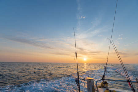 Fishing boat running in the sea shining in the morning sunの写真素材