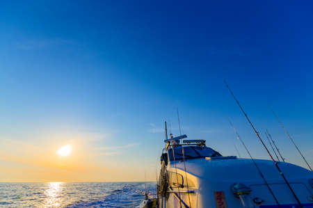 Fishing boat running in the sea shining in the morning sunの写真素材