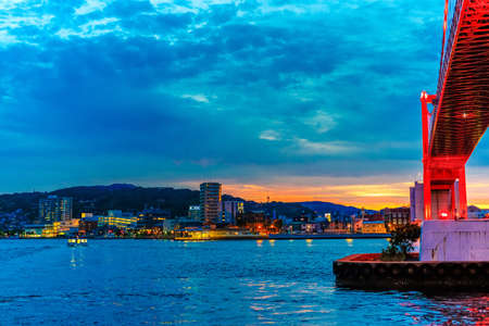 A beautiful red suspension bridge illuminated by the sunsetのeditorial素材