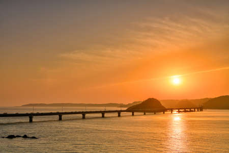 Kadoshima Bridge is surrounded by a beautiful orange sunset.の写真素材