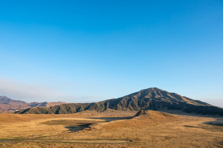 View of the volcanic plume of Aso Nakadake and the meadows around itの写真素材