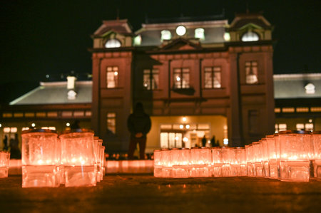 A beautiful view of Mojiko Station at night with candles decorating the square in front of it.のeditorial素材