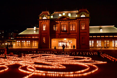 A beautiful view of Mojiko Station at night with candles decorating the square in front of it.のeditorial素材