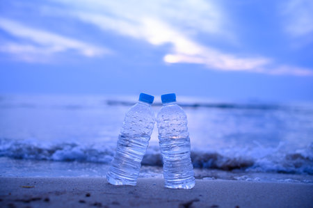Bottles of water on the beach at sunset time. Selective focus.の写真素材