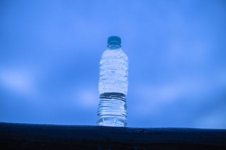 Bottle of water on blue sky background, closeup of photo