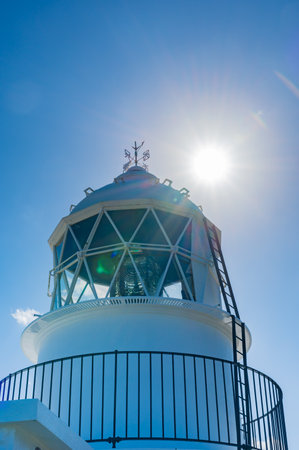 Lighthouse on blue sky background with sun beam and lens flare.の写真素材