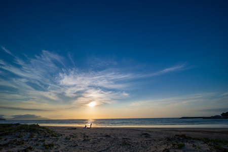 Silhouette of a man on the beach at sunset time.の写真素材