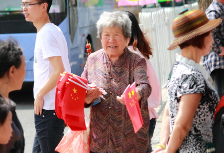 Beijing China - May 12,2012,Local elderly lady trying to sell souvenirs to tourists in front of Qien Men Front gate  Beijing Chinaのeditorial素材
