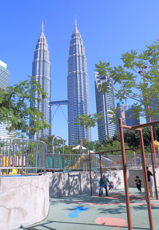 Kuala Lumpur Malaysia - 25 May, 2014  Local family play at playing ground near Petronas towers in...
