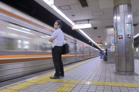 Osaka, Japan - 3 June, 2014  Japanese business man waits for subway at Osaka Subway station in Osaka Japan  のeditorial素材