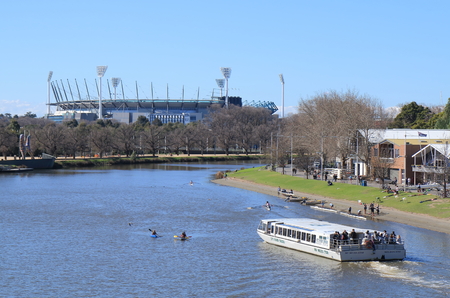 Melbourne Australia - August 23, 2014: Sightseeing boat cruises in Yarra river, MCG in background  のeditorial素材