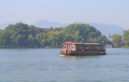 Hangzhou China - November 5, 2016: Unidentified people take a cruise boat in West lake.のeditorial素材