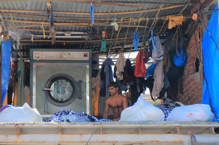 Mumbai India - October 12, 2017: Unidentified man works in Dhobi Ghat laundry Mumbai India.のeditorial素材