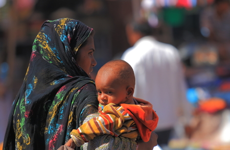 Jodhpur India - October 19, 2017: Unidentified woman cuddles a baby at Sardar street market in Jodhpur India.のeditorial素材
