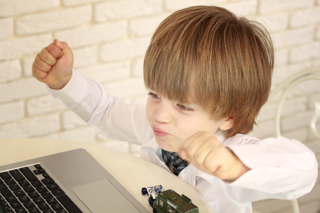 Emotional little boy using laptopの写真素材