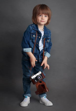 A little boy in denim and vintage camera.の写真素材