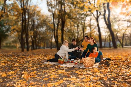 Happy friends having fun outdoor - people enjoying harvest time together outside at city parkの写真素材