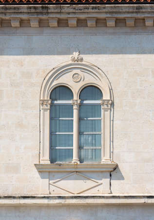 Fragment of the facade of a Mediterranean building with a beautiful window and relief decor. Croatiaの写真素材