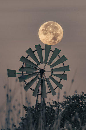 Vintage windmill in the field with full moon in the backgroundの写真素材