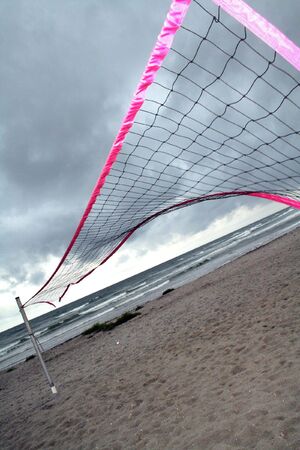 beach volley net at the end of season or on a bad weather stormy day. wind pull sports net on seashoreの写真素材
