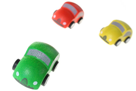 cars race isolated on white. toy vehicles in red, green and yellow compete to winの写真素材