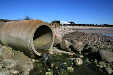 waste pipe or drainage polluting environment. concrete pipes by beachの写真素材