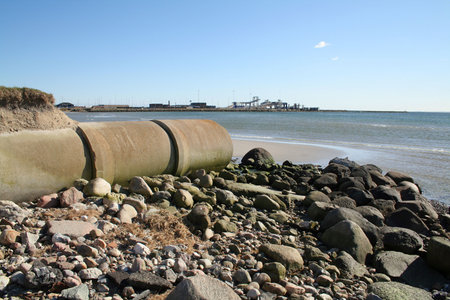 waste pipe or drainage polluting environment. concrete pipes by beach