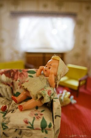 dollhouse with doll in living room on sofa. old antique childs toyの写真素材