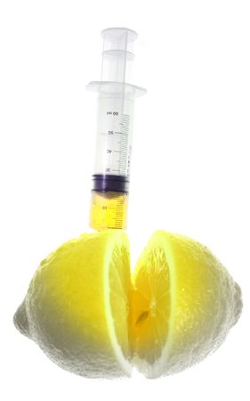 Genetically modified food. Lemon with syringe inject color isolated on whiteの写真素材