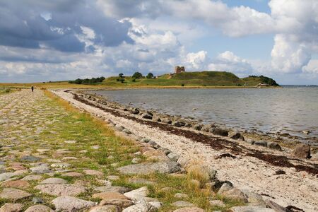 landscape with castle ruin in background. nature by sea or ocean with island and kalo fortication in denmark on molsの写真素材